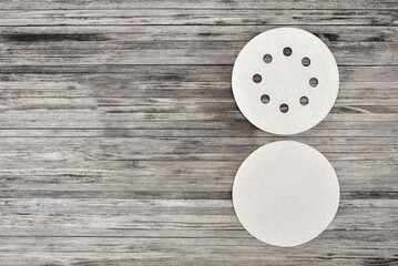 Round sandpaper discs for orbital sander. Adhesive sanding discs on a wooden background with copy space.