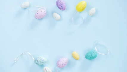 Pastel colours easter eggs on blue background. Flat lay banner image with copy space