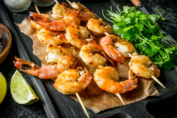 Grilled shrimps on a cutting Board with parsley and lime.