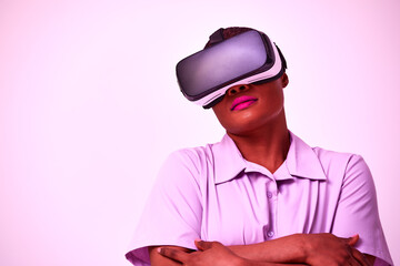 Young african american positive woman in black virtual reality glasses with vr headset posing, looking, playing and touching hands on purple background.