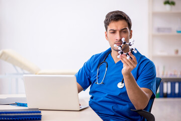 Young male student doctor holding molecular model