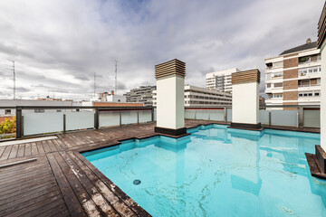 Rooftop terrace of a building with a summer pool and acacia wood floors