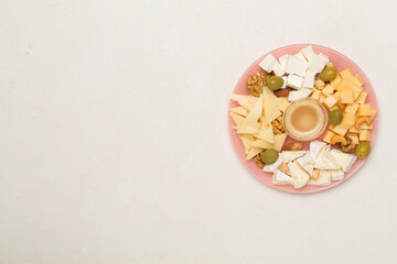 Cheese plate with olives aand nuts on concrete background, top view