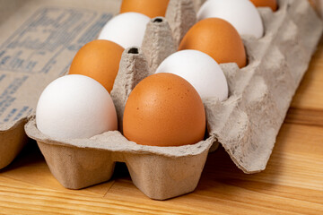 Fresh brown and white chicken eggs in carton. Organic, cage-free and poultry farming concept. 