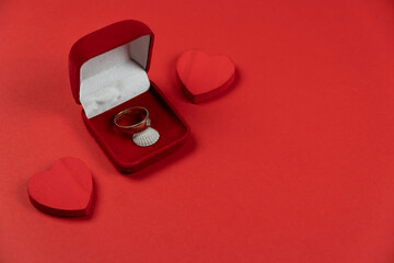 czerwone pudełko z pierścionkiem i dwoma sercami
