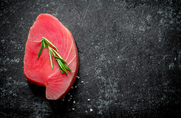 Piece of raw tuna with rosemary.