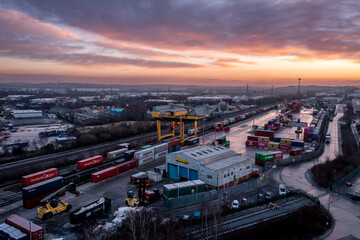 Aerial view of shipping containers at a rail and road terminal at sunrise