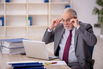 Old male employee working in the office