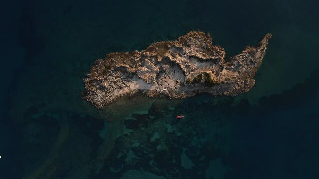 Aerial view of a rocky island near the coast of Turkey, surrounded by crystal clear waters of the Mediterranean sea. Inhabited by locals, a perfect escape from the hustle and bustle of city life