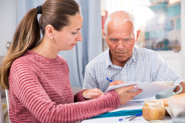 Mature father and adult daughter fill out paperwork. High quality photo