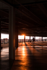 Man walking with a market car in a parking and sunset at background	