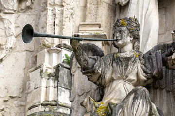 Statue of angel with trumplet on the facade of the ancient Church of the Holy Cross in Coimbra