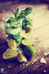 summer coctail background with fresh Mojito over rustic wooden background