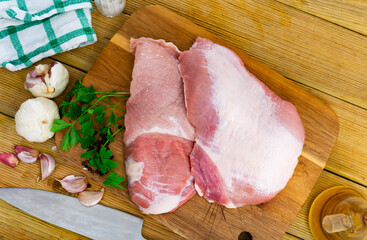Raw slice of Iberian pork secret and parsley on kitchen board
