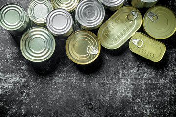 A group of closed aluminum cans with canned food.