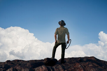 a traveler tourist dressed as Indiana Jones stands on top of a mountain as a symbol of travel and tourism render 3d
