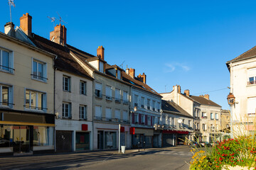 Fototapeta na wymiar Street of Montmirail, Marne department, France. View of neat buildings with signboards.