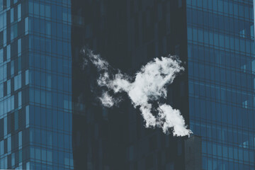 Smoke vapor from chimney in winter City business buildings architecture exterior abstract balanced pattern glass windows reflection in New York city