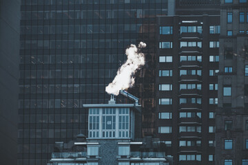 Smoke vapor from chimney in winter City business buildings architecture exterior abstract balanced pattern glass windows reflection in New York city