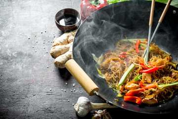 Freshly cooked Chinese noodles wok funchoza with salmon, vegetables and sauce.