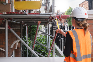 Civil engineer woman carrying out an inspection and supervising a construction site building,...