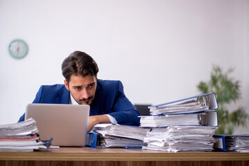 Young male employee and too much work in the office