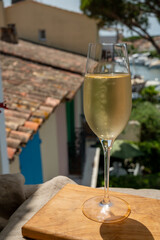Drinking of French brut champagne sparkling wine in glasses in yacht harbour of Port Grimaud near Saint-Tropez, French Riviera vacation, France