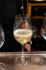 Pouring of txakoli or chacolí slightly sparkling very dry white wine produced in Spanish Basque Country in pinchos bar in old part of San Sebastian or Donostia, Spain