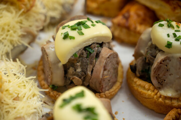 French mini quiche pie with goat cheese and traditional French sausage Andouillette from Troyes in bakery