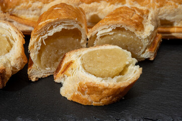 Fresh baked Dutch filled spicy cookies from puff pastry with almonds in autumn colors on dark stone