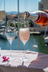 Drinking of French brut champagne sparkling wine in glasses in yacht harbour of Port Grimaud near Saint-Tropez, French Riviera vacation, France