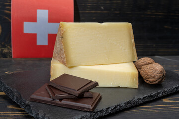 Swiss medium-hard cow milk cheese Gruyere, appenzeller, dark swiss chocolate and flag of Switzerland
