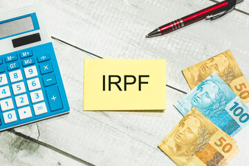 As iniciais IRPF de Imposto de Renda da Pessoa Física escritas em um pedaço de papel que está...