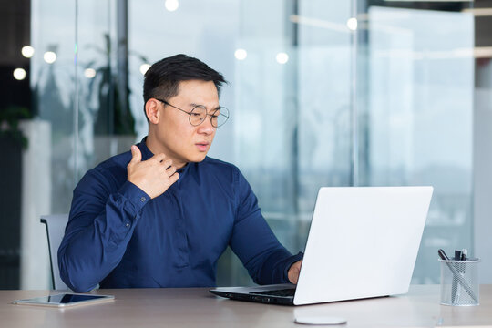 Heat And Heat In The Office, Broken Air Conditioner, Asian Man Has Nothing To Breathe, Businessman Lacks Fresh Air, Man Works Inside The Office Wearing Glasses And Using A Laptop At Work.