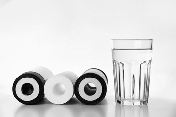 Banner of three of cartridges for water filter with clear fresh glass of water isolated on white...
