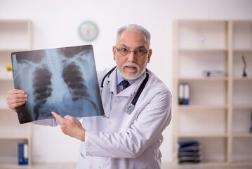 Old male doctor radiologist working in the clinic