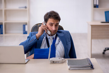 Young male employee after car accident at workplace