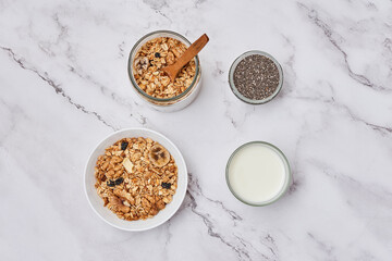 oats and yories on a marble counter top with milk, granos, almonds, chia