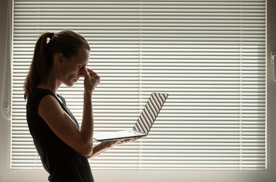 Shot Of Stressed Business Woman Working From Home On Laptop Looking Worried, Tired And Overwhelmed.