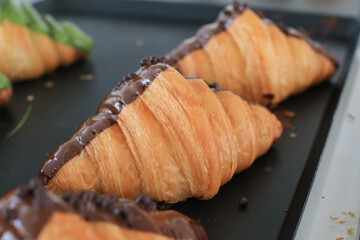 Fresh croissant with chocolate on black background. Delicious French pastry Baking Top View Copy space for Text. 