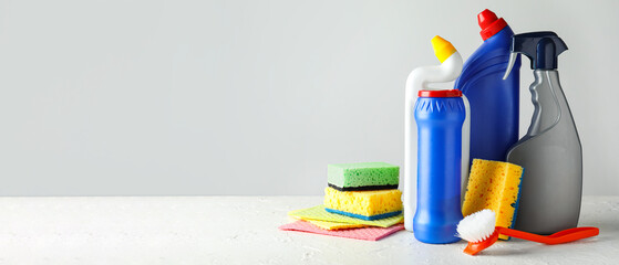 Set of cleaning supplies on light background with space for text