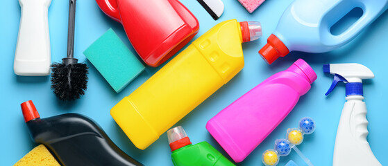 Different cleaning supplies on light blue background, top view