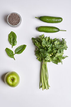 some vegetables and an apple on a white surface, with the ingredients to be used for this recipe photo is taken from above
