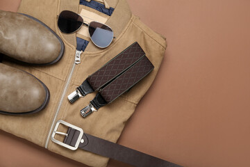 Male jacket, shoes and accessories on brown background