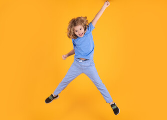 Fototapeta na wymiar Full body of little child jump wear casual t-shirt and jeans isolated on yellow background.