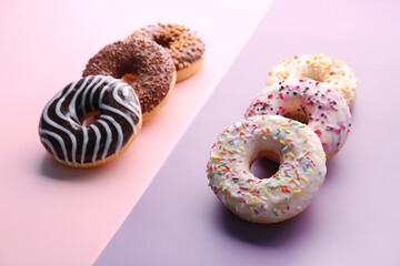 Delicious glazed donuts on color background