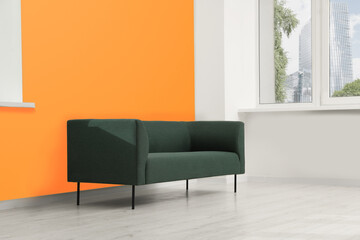 Beautiful interior with sofa near orange wall