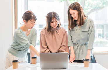 パソコンを使いながら会議・ミーティング・打ち合わせするアジア人女性・ビジネスウーマン(営業・企画)
