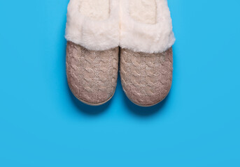 Pair of beautiful soft slippers on light blue background, top view. Space for text