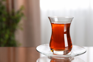 Glass with tasty Turkish tea on brown table indoors, space for text